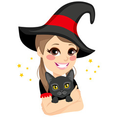 Beautiful teenage witch with big hat hugging magical black cat pet