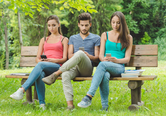 Teens at the park using smart phones