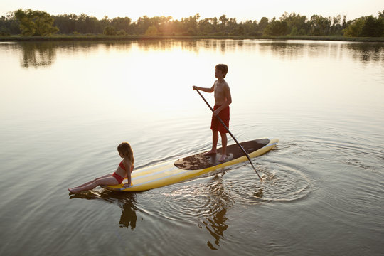 Children on paddleboard on lake