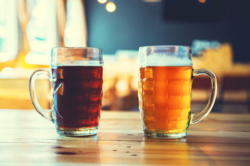 Goblets light and dark beer on a wooden table on a pub background. Assorted alcohol in a Flight Ready for Tasting