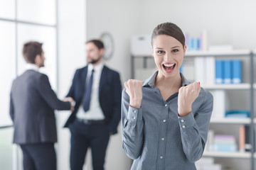 Cheerful businesswoman with raised fists