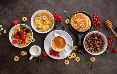 Breakfast cereals, pancakes, fresh berries and cup of coffee
