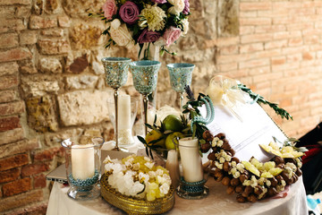 Table decor. High glasses pastel bouqet and white candles in blu