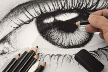 A hand drawing an eye charcoal artwork