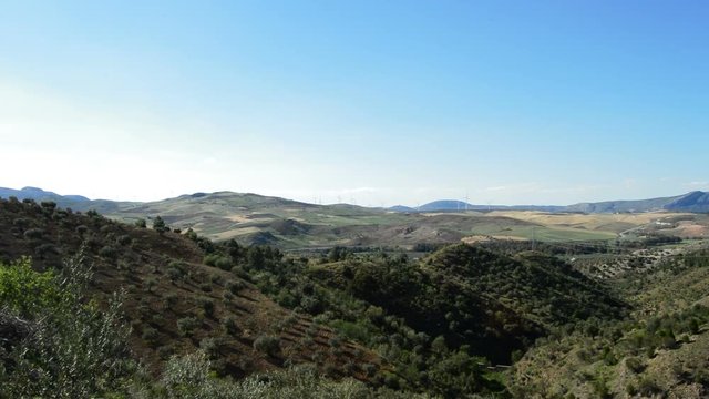 Mediterranean landscape with wind turbines energy at horizon at sunset