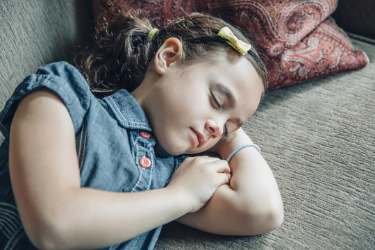 Mixed race girl sleeping on sofa