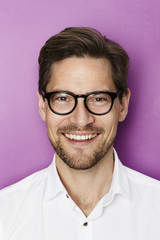 Portrait of smiling man in purple studio