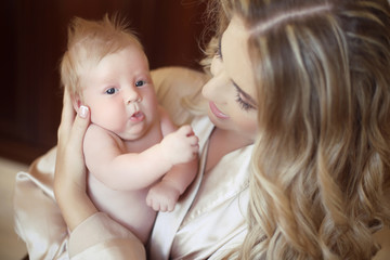 Beautiful mother with baby. Mom hugging her daughter child. Happ