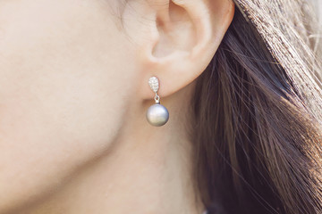 Fototapeta premium Woman ear wearing beautiful luxury earring