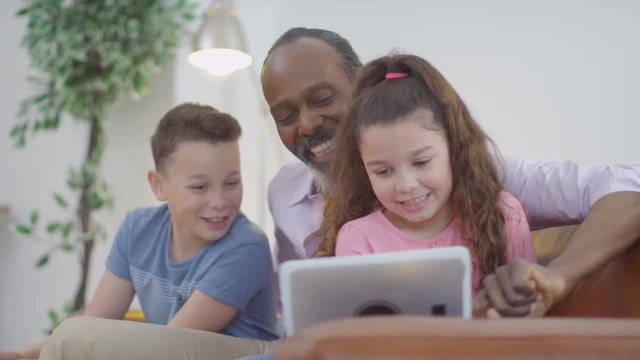  Happy grandfather & grandchildren taking selfie with computer tablet