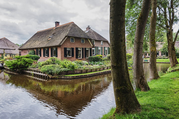 Fototapeta na wymiar The house stands between the channels in the Dutch village of Giethoorn