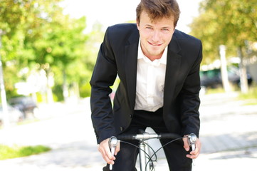 junger Mann im Anzug auf einem Rennrad