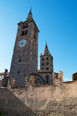 Fototapeta na wymiar Aosta, Valle d'Aosta, Italia: vista della torre dell'orologio e del campanile della cattedrale di Santa Maria Assunta e San Giovanni Battista il 29 luglio 2016