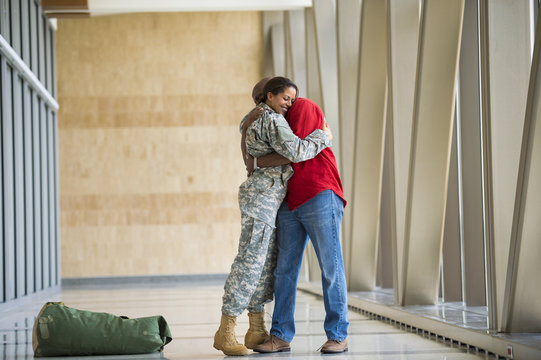 African American soldier hugging husband in airport