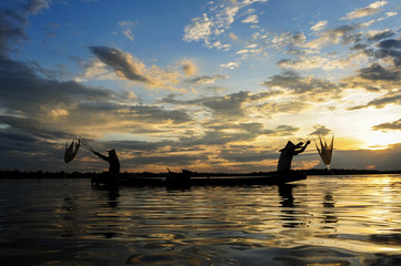 Fototapeta premium The siluate fisherman casting a net into the water during on sunset,Nongkhai Thailand