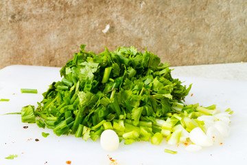 sliced green onions and chopped fresh cilantro on floor