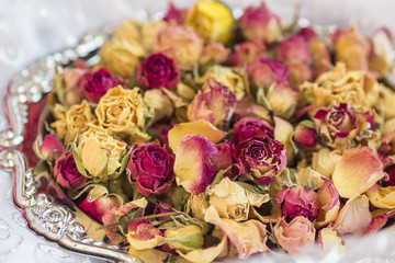 Beautiful dry roses on a silver tray