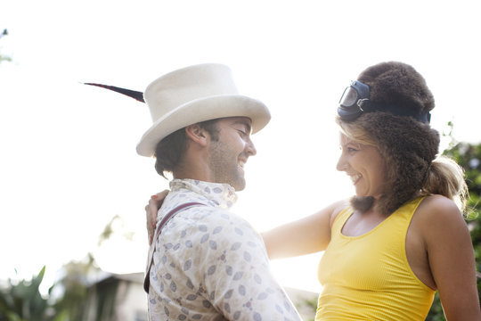 Caucasian couple in funny hats hugging