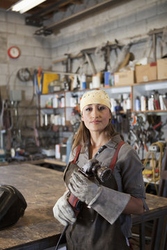Hispanic factory worker holding metal fabricator