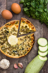 French quiche Lorraine with vegetables on a rustic wooden table

