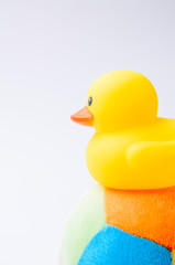 Yellow duck toy on toy soccer ball with white background