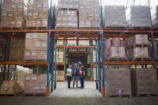 Workers talking in warehouse - Powered by Adobe