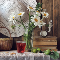 Still life with a bouquet of daisies and berries compote in the