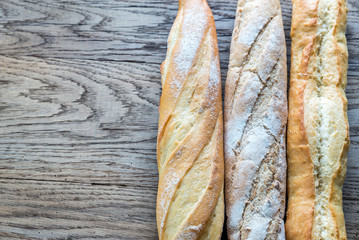 Three baguettes on the wooden background