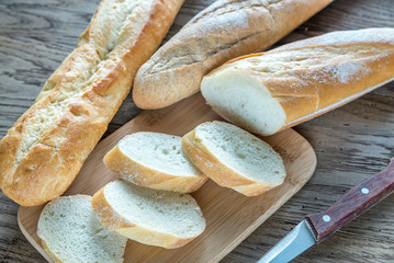Three baguettes on the wooden background