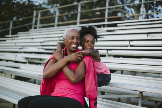 Grandmother and granddaughter sitting on bleachers