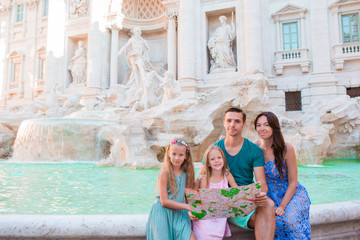 Family with touristic map near Fontana di Trevi, Rome, Italy. Happy father and kids enjoy italian vacation holiday in Europe.