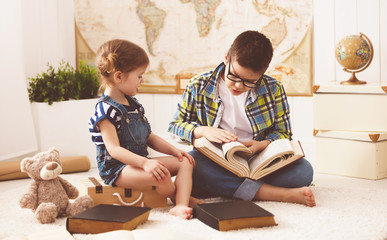 children brother and sister, boy and girl reading a book