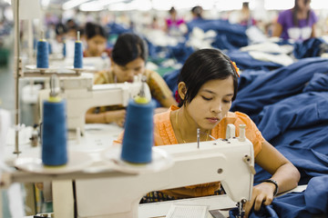 Asian worker sewing clothing in garment factory
