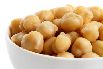 Detail of cooked chickpeas in white bowl on white.