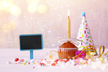 Birthday concept with cupcake and candle next to chalkboard