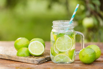 Fresh drink lemonade mojito in mason jar on wooden background.