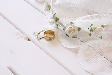 Wedding rings and white floral tiara on toilette table