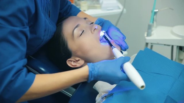 Dentis puts dental fillings with blue light