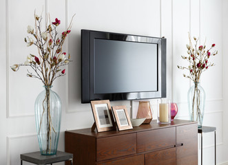 large modern TV on a white wall in the interior of the room