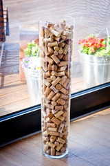 wine corks in a vase on a wooden background