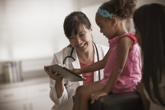 Doctor showing girl digital tablet