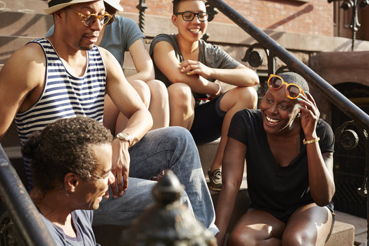 Friends sitting on steps and laughing