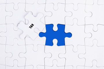 TAX WORD, WHITE AND BLUE MISSING PUZZLE WITH COPY SPACE AREA.