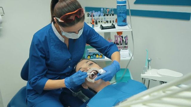 Woman at the dentist treats a teeth