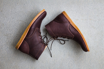 Men's accessories with brown leather boots on gray grunge background