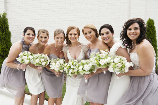 Smiling bridal party standing with bride