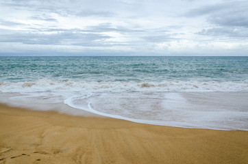 Fototapeta na wymiar Cloudy Beach and Wave