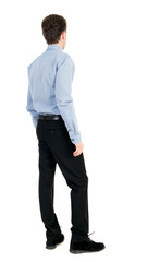 back view of Business man  looks.  Rear view people collection.  backside view of person.  Isolated over white background. The curly-haired businessman in light shirt stands sideways and looks forward