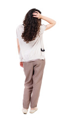 back view of standing young beautiful  woman.  girl  watching. Rear view people collection.  backside view of person. Long-haired girl straightens curly hair.  