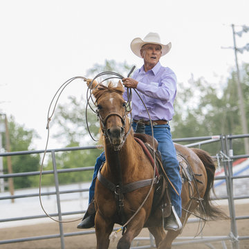 Caucasian cowboy riding horse in rodeo